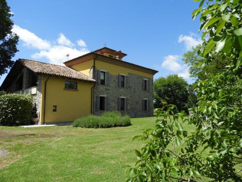 an old stone house in a field of grass at Monte Cucco - Monticello Apartments in Medesano