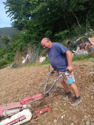 a man is standing next to a lawn mower at Agriturismo U muinettu in La Spezia