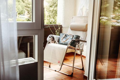 a chair on a porch next to a fireplace at Hotel Reindl Suiten & Appartments in Bad Füssing