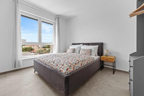 a bedroom with a bed and a large window at Peninsula Villas in Premantura