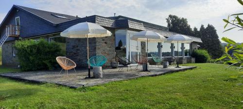 a group of chairs and umbrellas in front of a house at " NEW 2025 " Plein Vent 800m entrée Combes circuit Spa Francorchamps in Francorchamps