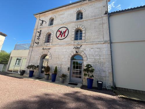 un bâtiment avec une horloge sur le côté dans l'établissement Le Moulin Neuf, à Le Gond-Pontouvre