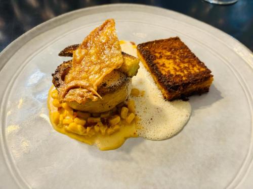 une plaque blanche avec de la nourriture sur une table dans l'établissement Le Moulin Neuf, à Le Gond-Pontouvre