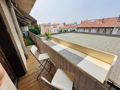 un balcon avec deux chaises et une table et un toit dans l'établissement Bel appartement centre Aix, à Aix-en-Provence