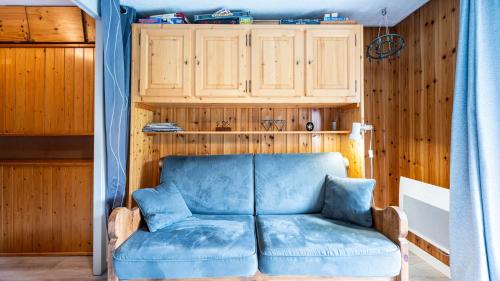ein blaues Sofa in einem Raum mit Holzwänden in der Unterkunft Hermine 1 N09 - 2P4 in Morillon