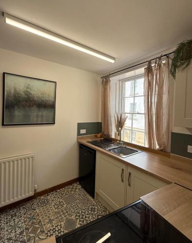 a kitchen with a counter and a sink and a window at Bow Alley Lodge in Alnwick