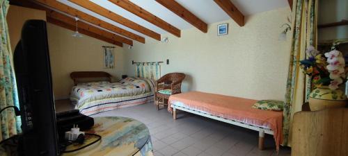 une chambre avec deux lits et une télévision dans l'établissement Maison familiale avec piscine près de la plage de Foulerot, à Saint-Georges-dʼOléron