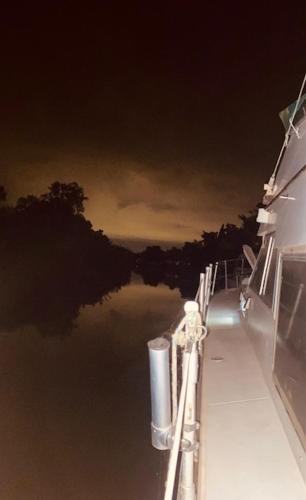 a boat in the water at night with a view at Bateau Péniche à quai 6 couchages in Colombiers