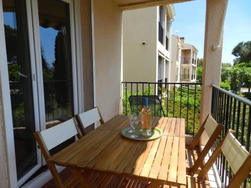 une table et des chaises en bois sur un balcon dans l'établissement Appartement 2 pièces 4 couchages LA LONDE LES MAURES LAL110-120, à La Londe-les-Maures