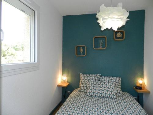 une chambre avec un lit, une fenêtre et un lustre dans l'établissement Appartement 2 pièces 4 couchages LA LONDE LES MAURES LAL110-120, à La Londe-les-Maures
