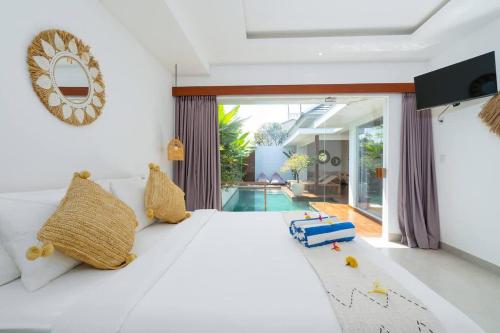 une chambre avec un lit blanc et une piscine dans l'établissement Villa Ryky near Luna Beach Club, à Cemagi