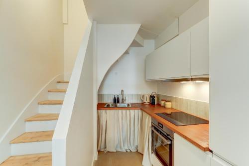 une cuisine avec des placards blancs et un escalier dans l'établissement Le Velours 2 bedrooms 4 beds central, à Lyon