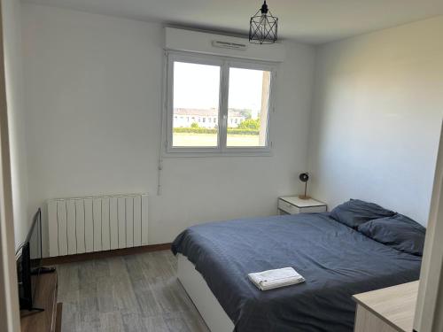 une chambre avec un lit et une fenêtre dans l'établissement Appartement Evreux, à Évreux