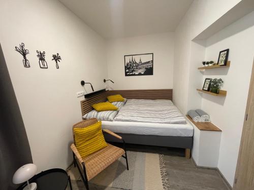 a small bedroom with a bed and a chair at Comfortable apartments under the St. Barbara´s Cathedral in Kutná Hora
