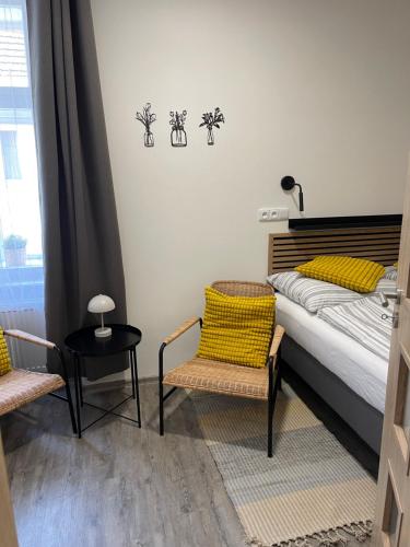 a bedroom with a bed and two chairs and a table at Comfortable apartments under the St. Barbara´s Cathedral in Kutná Hora