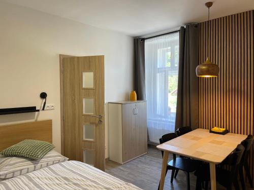 a bedroom with a bed and a table and a window at Comfortable apartments under the St. Barbara´s Cathedral in Kutná Hora