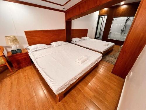 a bedroom with two beds and a wooden floor at An House, Farm & Trekking in Tam Ðảo