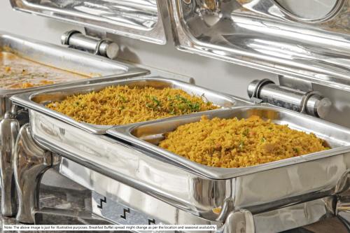 two metal trays of food in a buffet at Medalio Signature Chandigarh Zirakpur in Zirakpur