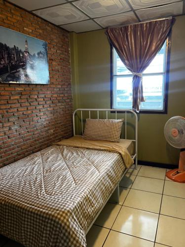 a bedroom with a bed and a brick wall at เวลาสุข in Phra Nakhon Si Ayutthaya