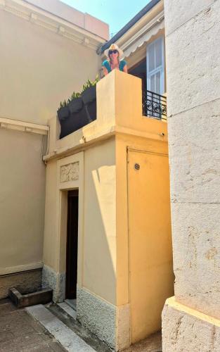 un homme debout sur un balcon d'un bâtiment dans l'établissement L'Appart by la Maïoun Guesthouse, à Nice