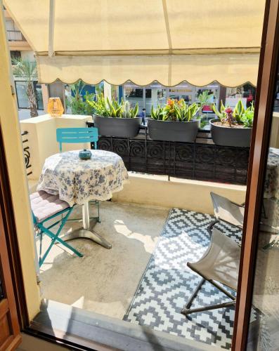 Elle offre une vue sur une terrasse avec une table et des chaises. dans l'établissement L'Appart by la Maïoun Guesthouse, à Nice