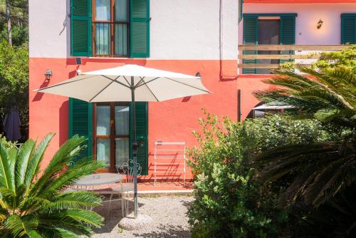 a white umbrella sitting in front of a building at Villa Gaia in Portoferraio