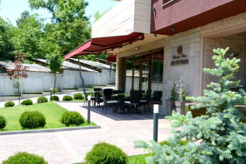 a patio with a table and chairs outside of a building at Victoriya's House in Hisarya