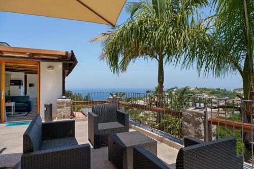a patio with chairs and a view of the ocean at Villa Panorama Isola di Ischia in Casamicciola Terme