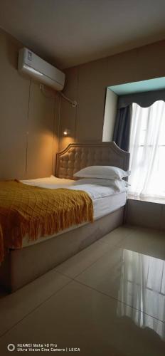 a bedroom with a large bed with a window at YuMi Gaopai in Guangzhou
