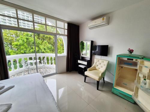 a room with a bed and a chair and a window at Dorothys in Pattaya South