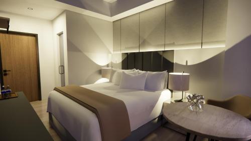 a hotel room with a bed and a table at Vibe Hotel Alabang in Manila