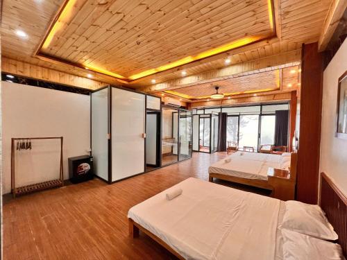 a large room with two beds and a tv at An House, Farm & Trekking in Tam Ðảo