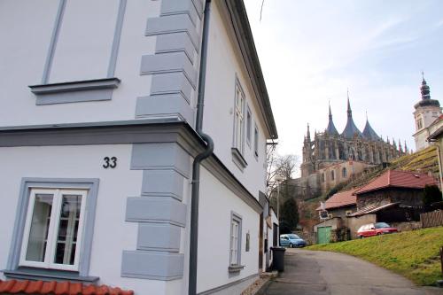 a white building next to a street with a cathedral at Comfortable apartments under the St. Barbara´s Cathedral in Kutná Hora