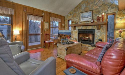 a living room with a leather couch and a fireplace at American Dream Americana decor close to downtown Blue Ridge in Blue Ridge