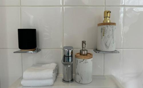 a bathroom counter with two soap dispensers and towels at Central Guest Studio - En-Suite - Vibrant London in London