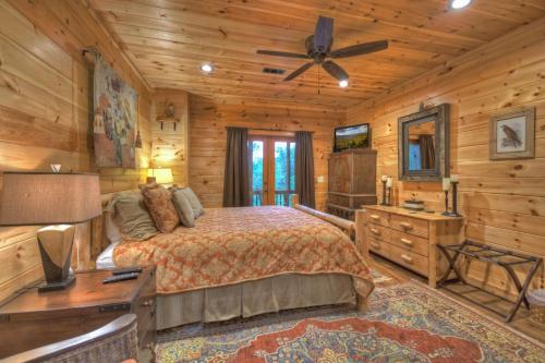 ein Schlafzimmer mit einem Bett und einem Deckenventilator in der Unterkunft Pursuit of Happiness Mountain luxury hot tub big-screen TVs pet-friendly in Mineral Bluff