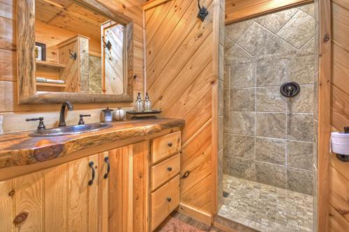 ein Badezimmer mit Waschbecken und Dusche in der Unterkunft Pursuit of Happiness Mountain luxury hot tub big-screen TVs pet-friendly in Mineral Bluff
