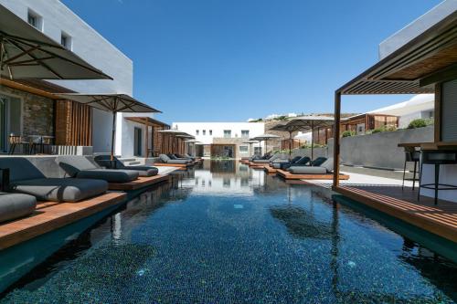 a swimming pool with lounge chairs and an infinity at Elia Mykonos Resort in Elia Beach