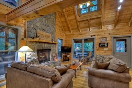 a living room with couches and a fireplace at K6 Lodge Gather around the firepit soak in the hot tub and splash in the creek in Blue Ridge