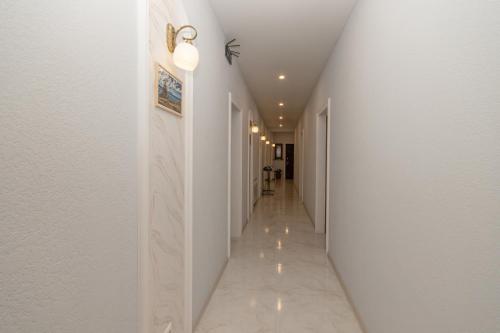 a hallway with white walls and a long hallway with white ceilings at Hillside Guest House in Yerevan