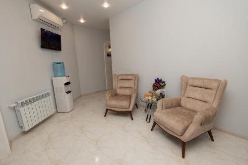 a room with two chairs and a table and a refrigerator at Hillside Guest House in Yerevan