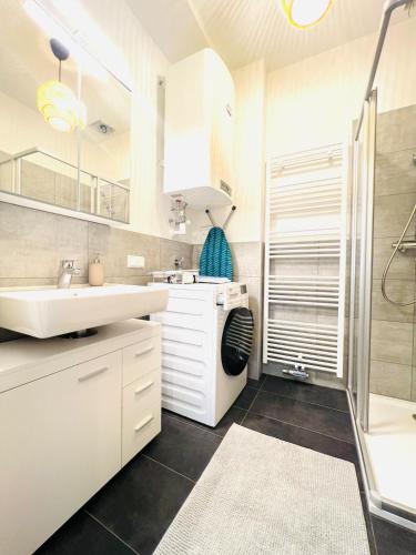 a white bathroom with a sink and a shower at 123 Apartment Graz - top 1 in Graz
