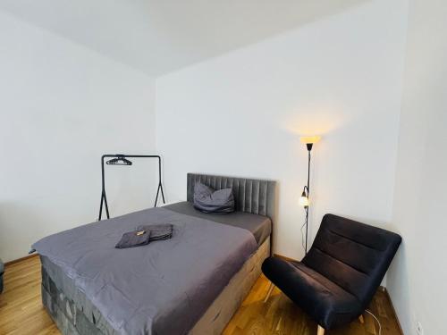 a bedroom with a bed with a chair and a lamp at 123 Apartment Graz - top 1 in Graz