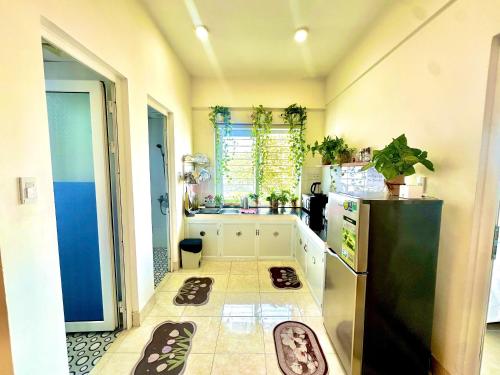 a kitchen with a black refrigerator and some shoes on the floor at SARAH HOMESTAY in Thôn Lại Thê