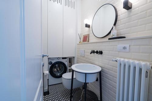 een badkamer met een wasmachine en een spiegel bij Casa Giallo village home-by Italian Apartaments in Lenno