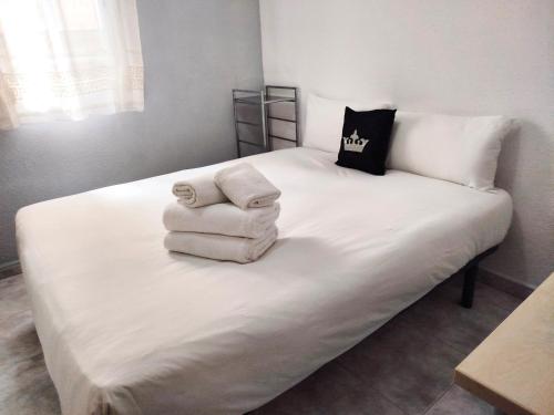 Una cama blanca con toallas encima. en La habitación de Santa Eulalia, en Hospitalet de Llobregat