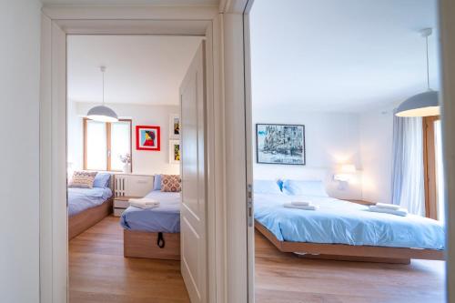 een slaapkamer met een bed, een bank en een spiegel bij Casa Giallo village home-by Italian Apartaments in Lenno