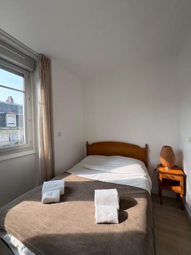 ein Schlafzimmer mit einem Bett mit zwei Handtüchern darauf in der Unterkunft Villa Médicis Besançon in Besançon