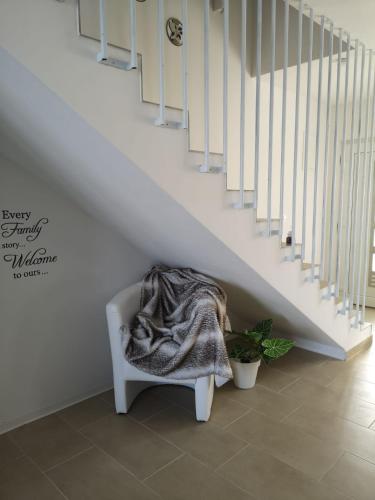 a blanket sitting on a chair under a staircase at Ferienhausanlage Adria Oasis in Višnjan