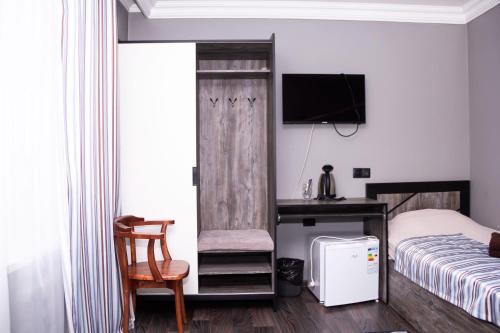 a bedroom with a bed and a desk with a computer at Hotel Tahar in Almaty